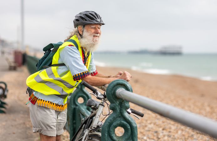 Calm mature man enjoying coastal view from bike