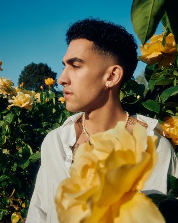 Male model in garden with yellow flowers