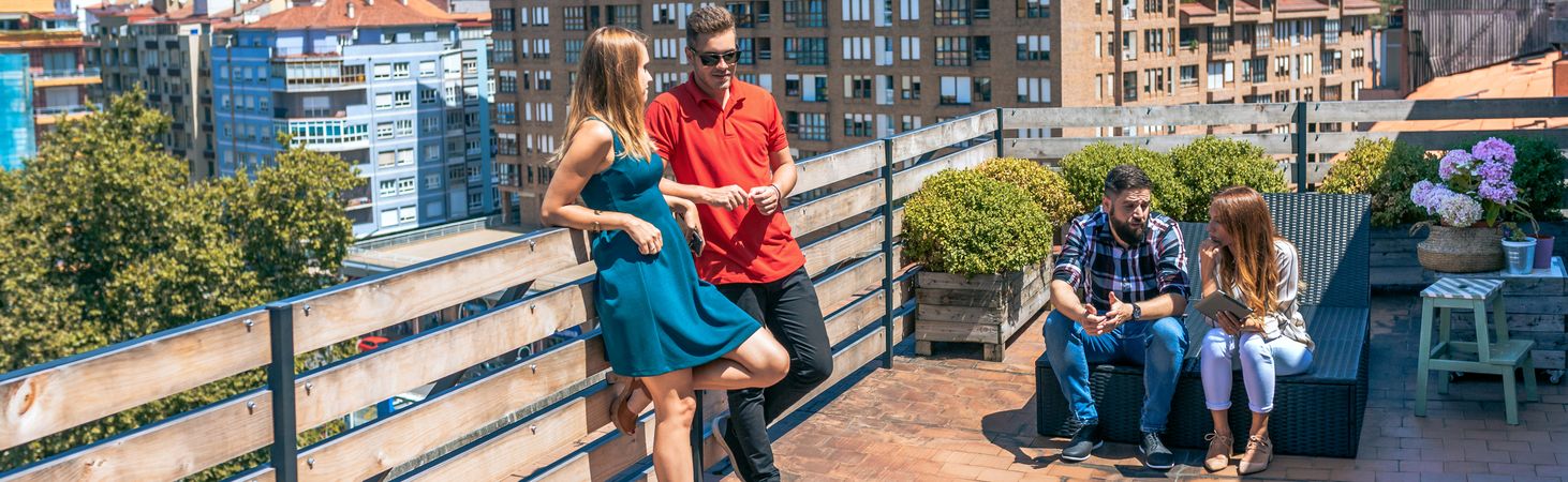 Couple talking next to friends in rooftop on a summer day