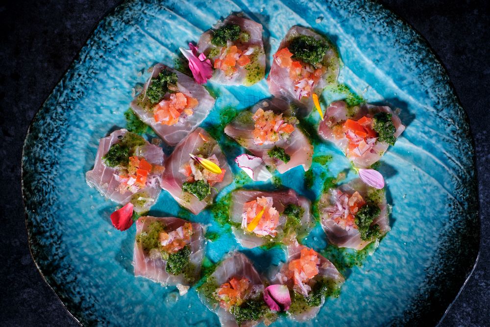 Plate with delicious fish dish on marble surface