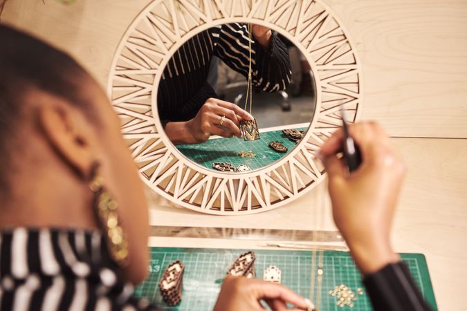 Rear shot of jewelry designer assembling a necklace