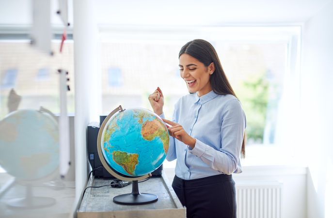 Happy woman with hand on globe