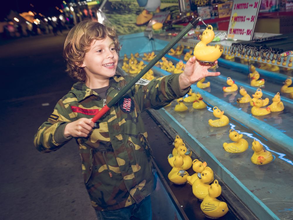 Kid catching rubber duck in amusement park