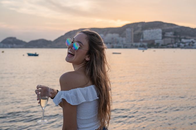 Young woman enjoying wine near sea
