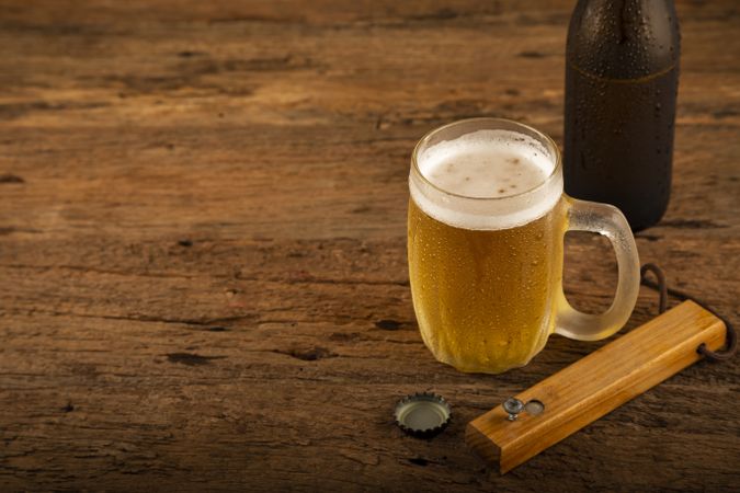 Glass full of cold beer on the wooden table