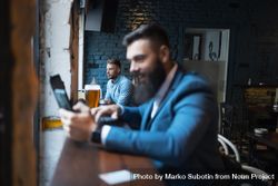 Two men sitting separate in a bar 4Zvyn4
