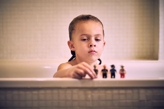 Boy in bathroom playing with toys