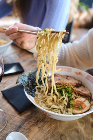 Crop person eating tasty ramen