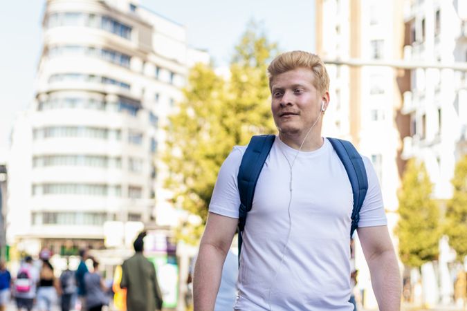 Young Latino man with albinism walking in the city street