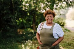 Portrait of older woman in overalls outside 56Kyd4
