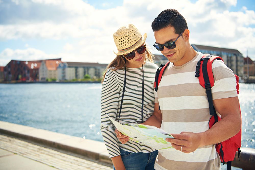 Couple on holiday checking map near river