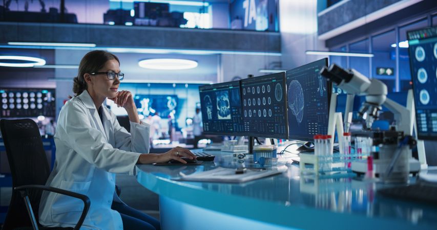 Medical Hospital Research Laboratory: Female Neurosurgeon Using Computer with Brain Scan MRI Images, Finding Best Treatment for Sick Patient.