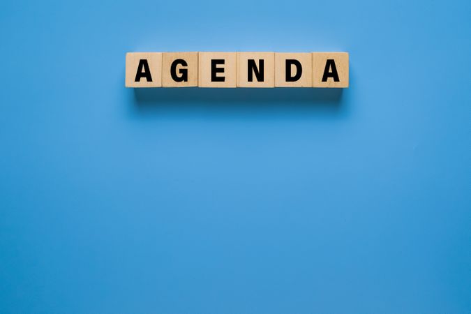 agenda word on wooden blocks. isolated on blue background. copy space