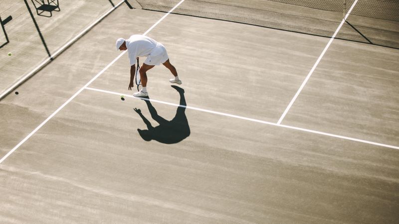 Aerial view of a man playing tennis on a sunny day