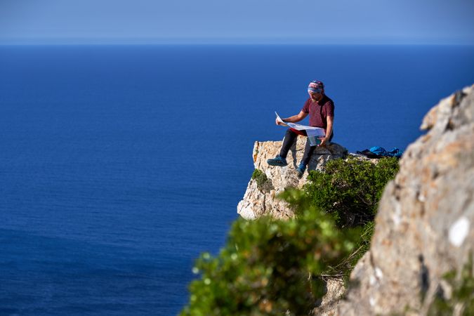 Male tourist reading paper map in mountains