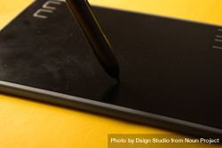 Close up of digital tablet and stylus on yellow table 5qkE1p
