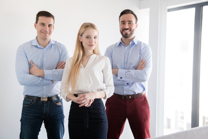 cheerful elegant man and woman using different gadgets while standing together in light office