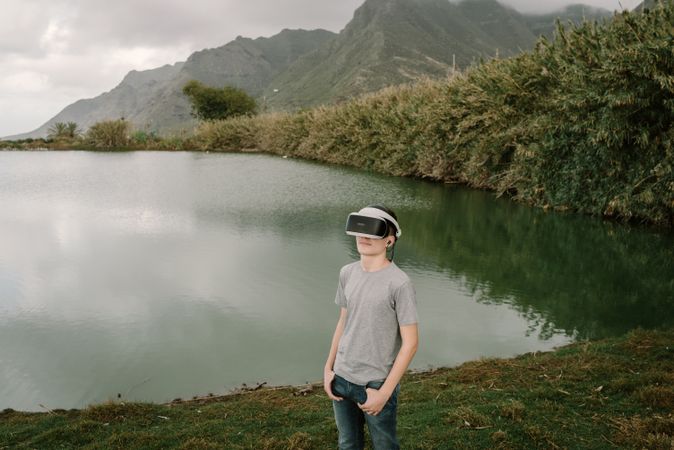 Young teenager with virtual reality glasses outdoors