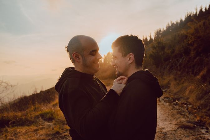 Men hugging and kissing in forest