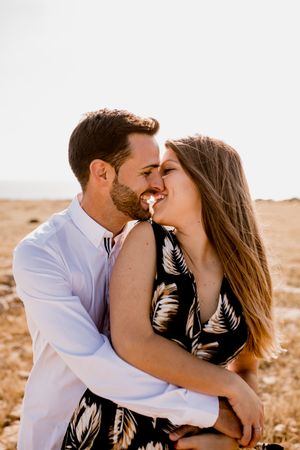 Peaceful lovers bonding on empty coastline