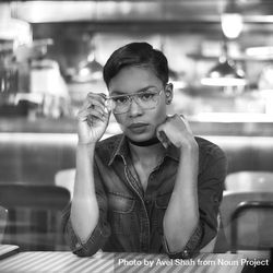 Monochrome image of woman at cafe table 5rLA2b