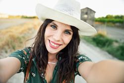 POV of happy brunette female taking a selfie