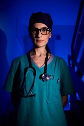 Professional female doctor in scrubs on staircase