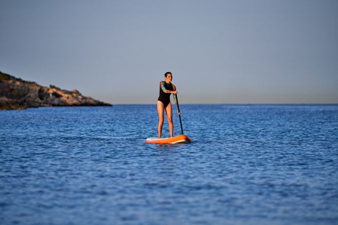 Fit woman on paddleboard in sea