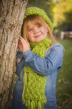 Portrait of Cute Young Girl Wearing Green Scarf and Hat