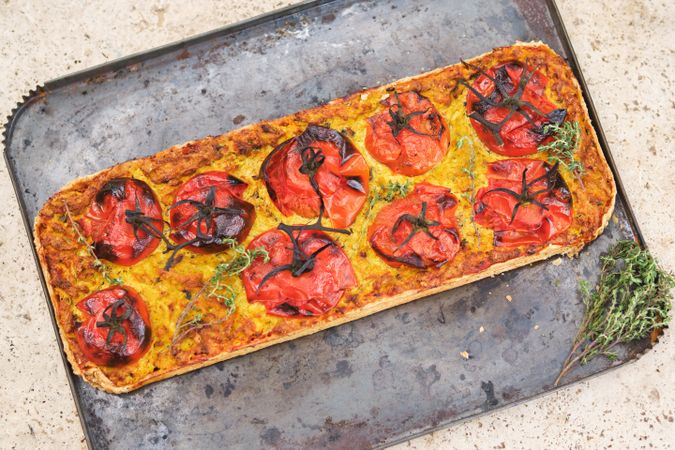 Delicious pizza with tomatoes on baking pan