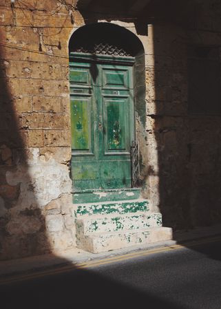 Green door and steps in the sunshine in Malta
