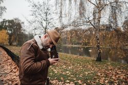 Male photographer standing in autumn park