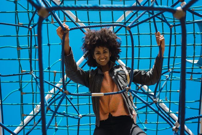 Woman with afro hair climbing by children's attractions.