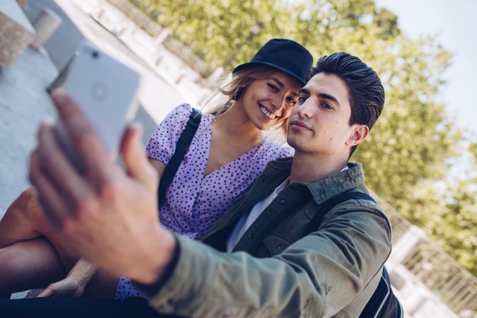 Happy young couple taking selfie in park