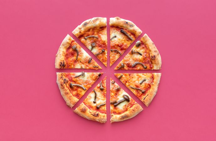 Sliced pizza top view on a magenta background