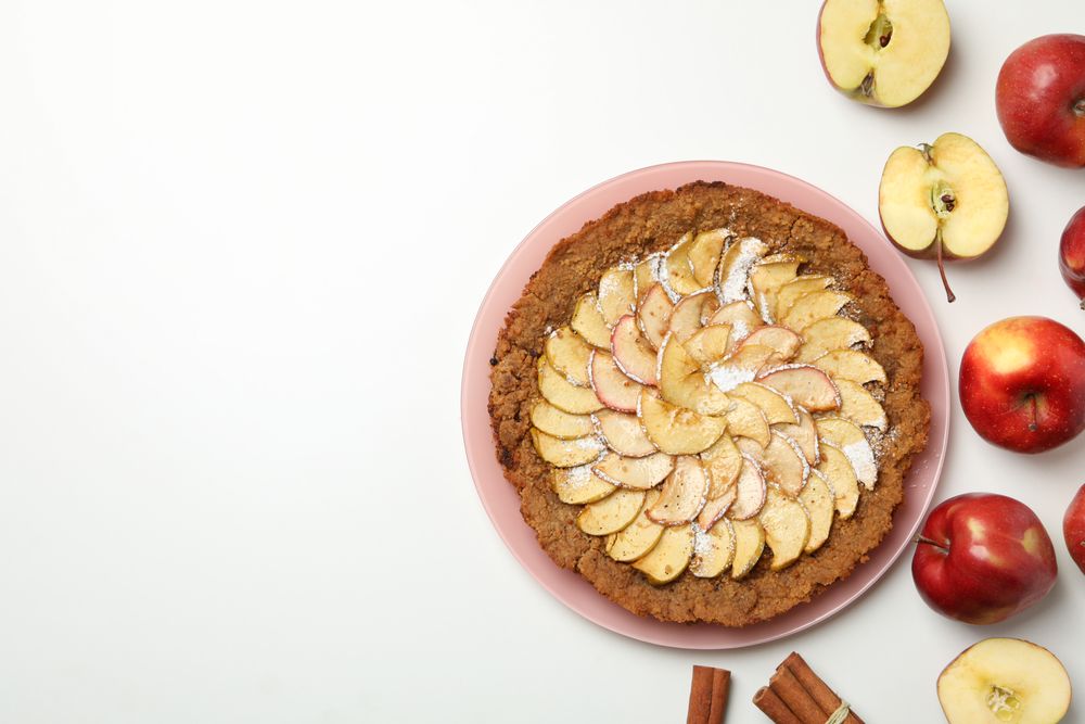 Composition with tasty apple pie on blank background, top view