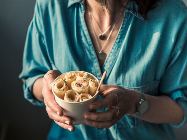 Hand holding rolled ice cream in cone cup