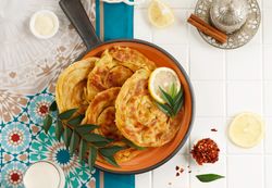 Top view of roti skillet served with citrus, tea and milk