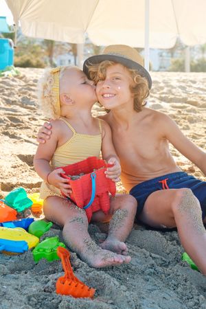 Happy little boy and girl on beach in summer
