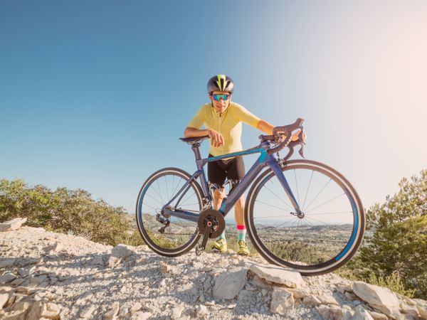man resting and enjoying the views while riding a bicycle on a mountain road