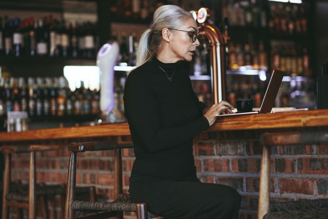 Mature businesswoman at coffee shop with laptop