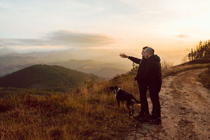 Men hugging on road on hill