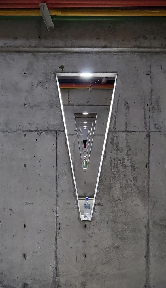 Interior perspective of symmetric triangular holes in a gray building