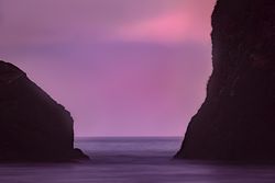 Purple hued sky between two rocks on the Pacific Coast