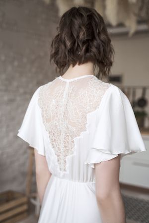 Young woman with in elegant white standing on room