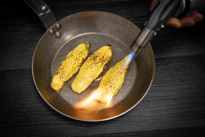 Person cooking endive with burner in pan