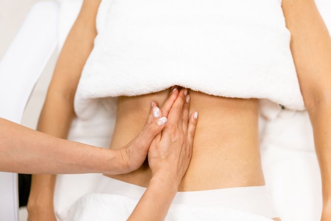 Massage therapist working on a female client’s torso