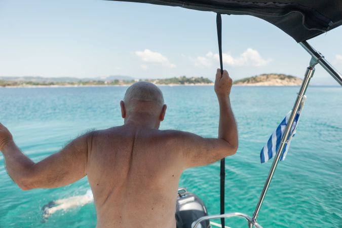 Man sailing in boat in clear turquoise water