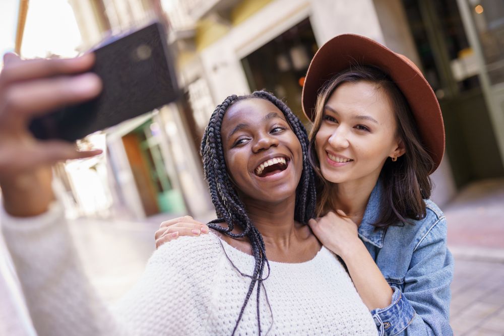 Female friends smiling at camera phone for a selfie