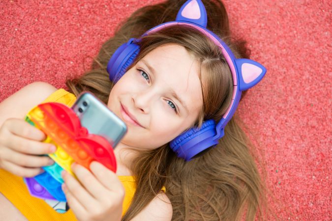 Happy girl with colorful toy and smartphone